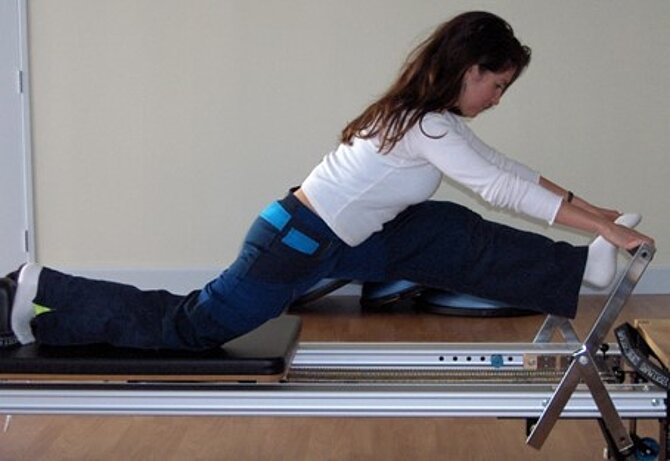 Foto van een mevrouw in een Pilates houding
