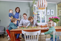 Foto van gezin met drie kinderen aan tafel