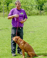 Foto van een man met een hond aan de lijn (Ron's Dog Care)