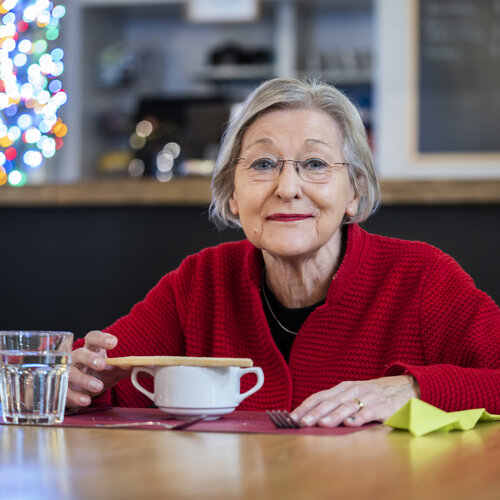 Foto van seniore vrouw met een lekker soepie