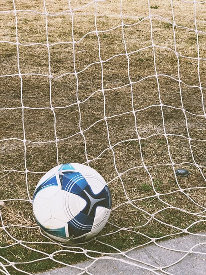 Foto van een voetbal in het doel (Unsplash Freestock)