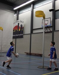 Foto van twee jongens die korfbal spelen