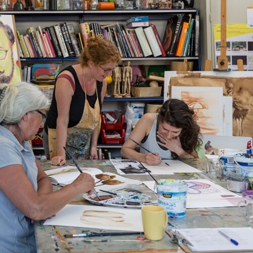 Drie vrouwen zijn aan aan het schilderen