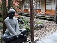 Fot van een stenen boedha beeld in een Oosterse tuin