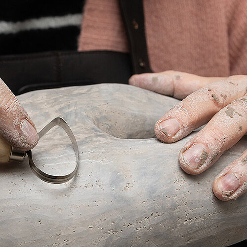 Foto van 2 handen die aan het boetseren zijn