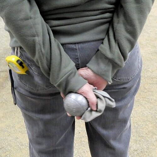 Foto van iemand die twee jeu de boules ballen vasthoud