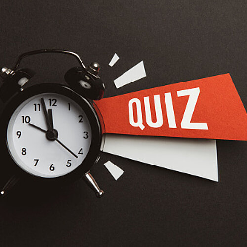 Foto van een wekker en het woord Quiz