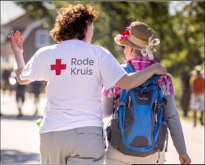 Foto van een medewerker Rode Kruis en een wandelaar